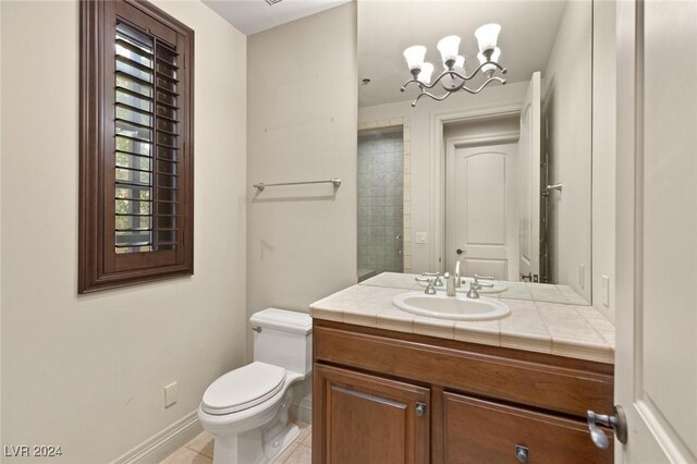 bathroom with a notable chandelier, toilet, tile patterned floors, and vanity