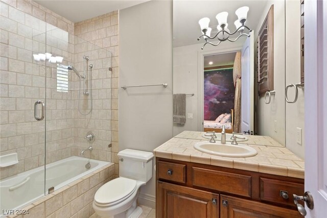 full bathroom featuring a notable chandelier, bath / shower combo with glass door, toilet, and vanity