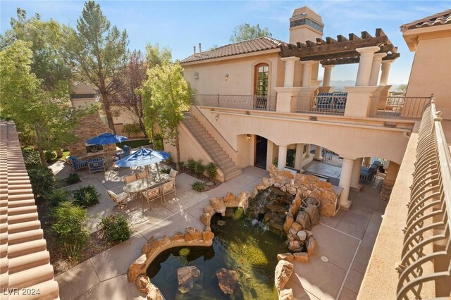 exterior space with a balcony, a pergola, and a patio