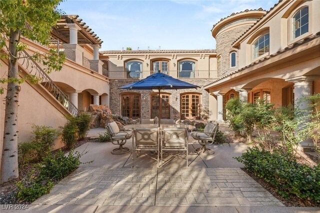 exterior space featuring a patio area, a balcony, and french doors