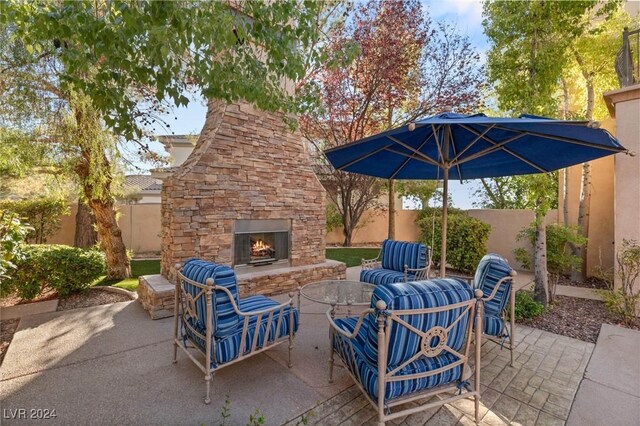 view of patio with an outdoor living space with a fireplace