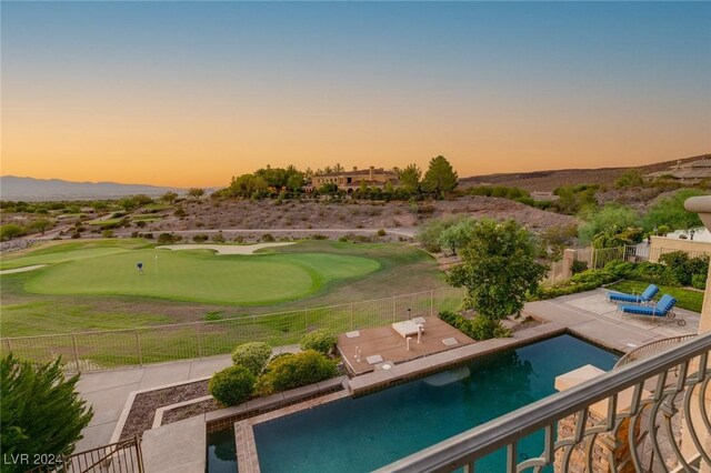 pool at dusk featuring a patio area