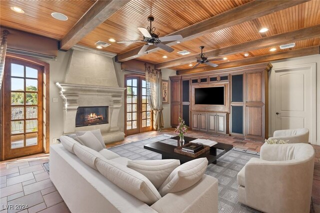 living room featuring beamed ceiling, a fireplace, light tile patterned floors, ceiling fan, and wooden ceiling