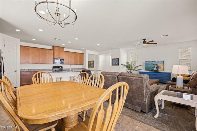 dining area featuring ceiling fan with notable chandelier and light tile patterned floors