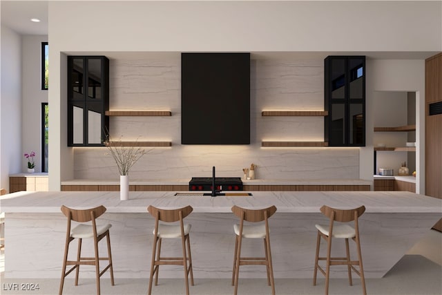 kitchen with light countertops, a sink, a kitchen breakfast bar, and open shelves