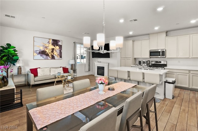 dining area with sink and light hardwood / wood-style flooring