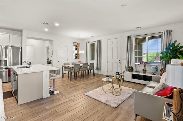 living room with sink and light hardwood / wood-style flooring