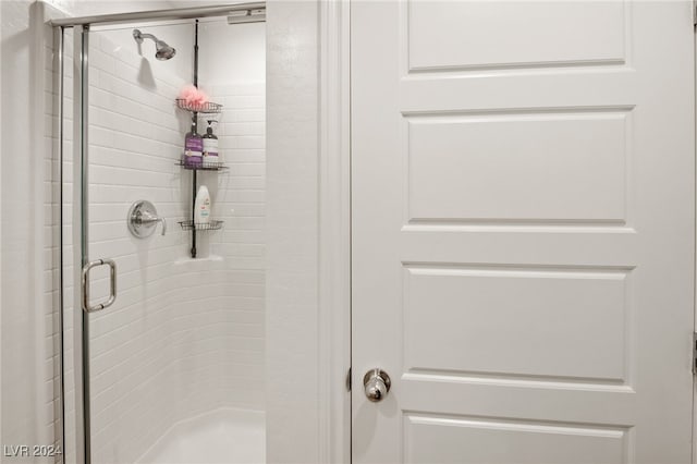 bathroom with a shower with door