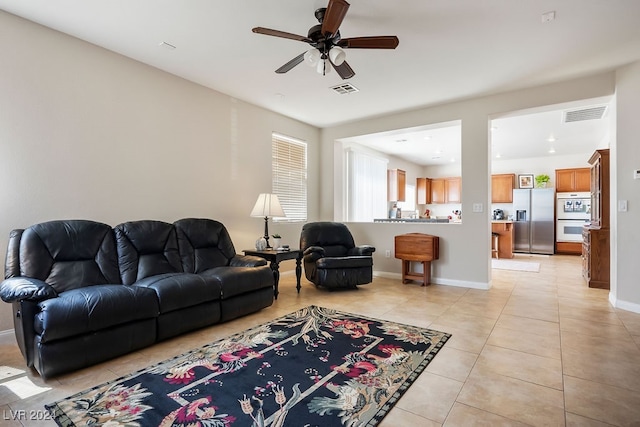 tiled living room with ceiling fan