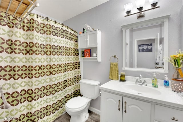 bathroom featuring toilet, wood finished floors, and vanity