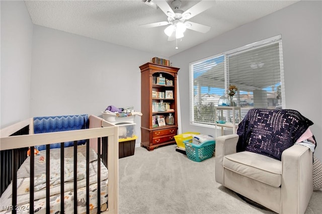 carpeted bedroom featuring ceiling fan and a textured ceiling