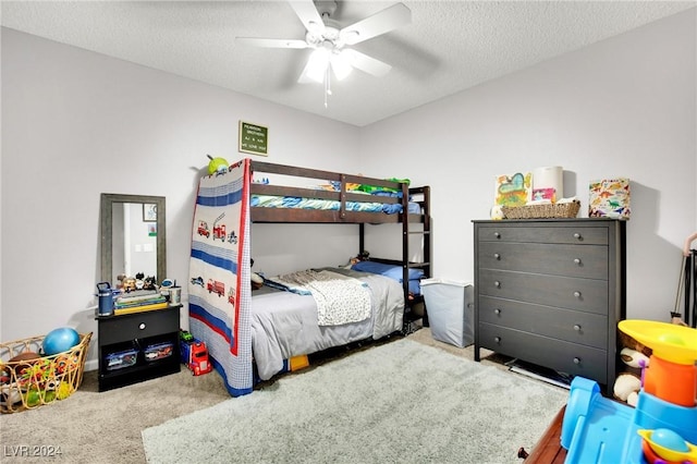 carpeted bedroom with ceiling fan and a textured ceiling