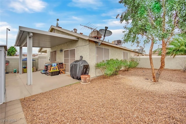 rear view of house featuring a fenced backyard, a patio, and stucco siding