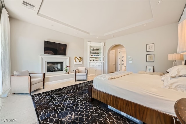 bedroom with a raised ceiling and tile patterned floors