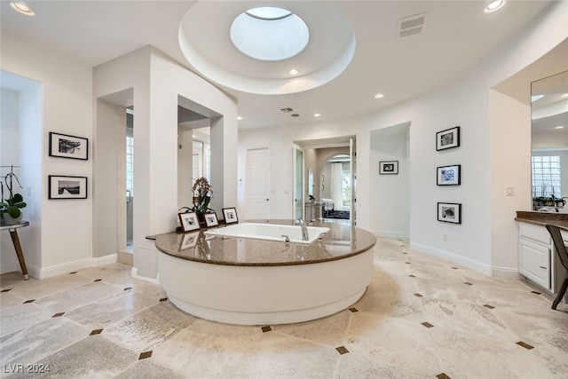 bathroom with tile patterned flooring, vanity, a tray ceiling, and shower with separate bathtub