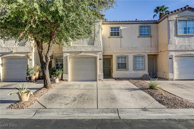 view of front facade with a garage, concrete driveway, and stucco siding