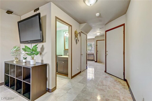 hallway featuring marble finish floor, visible vents, and baseboards