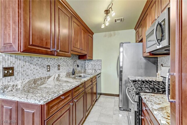 kitchen featuring backsplash, sink, light stone counters, light tile patterned floors, and stainless steel appliances