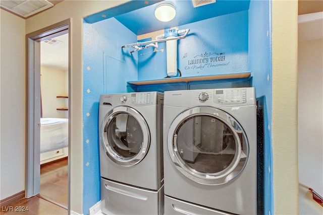 laundry room with separate washer and dryer and wood-type flooring