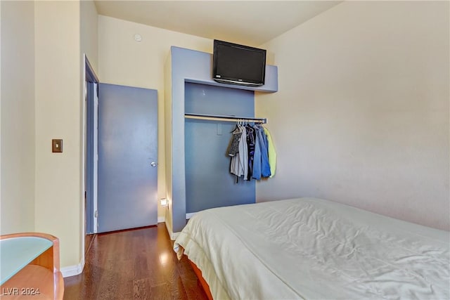 bedroom featuring dark wood-style floors and baseboards