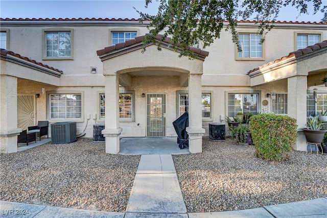 view of front of property featuring central AC unit and a patio