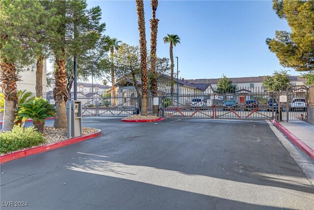 view of street with a residential view, a gate, curbs, and a gated entry