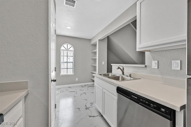 kitchen with stainless steel dishwasher, white cabinetry, light tile patterned floors, sink, and a textured ceiling