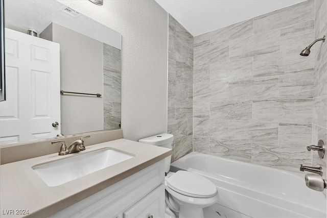 full bathroom featuring tiled shower / bath combo, toilet, and vanity