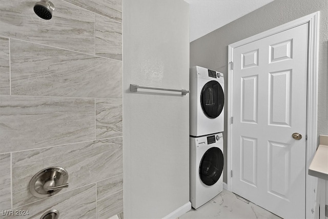 laundry room with stacked washer and clothes dryer and light tile patterned floors