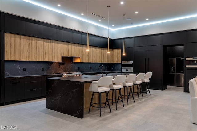 kitchen featuring a spacious island, tasteful backsplash, pendant lighting, light tile patterned floors, and a breakfast bar