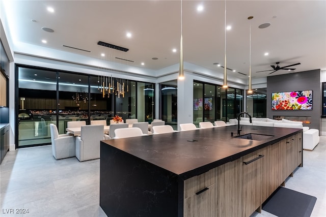 kitchen featuring sink, a large island with sink, pendant lighting, and ceiling fan