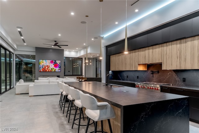 kitchen with ceiling fan, a breakfast bar, range, sink, and decorative light fixtures