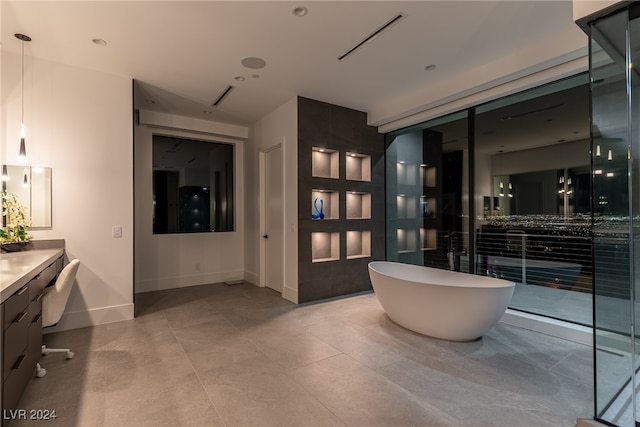 bathroom with tile patterned flooring, a washtub, and vanity