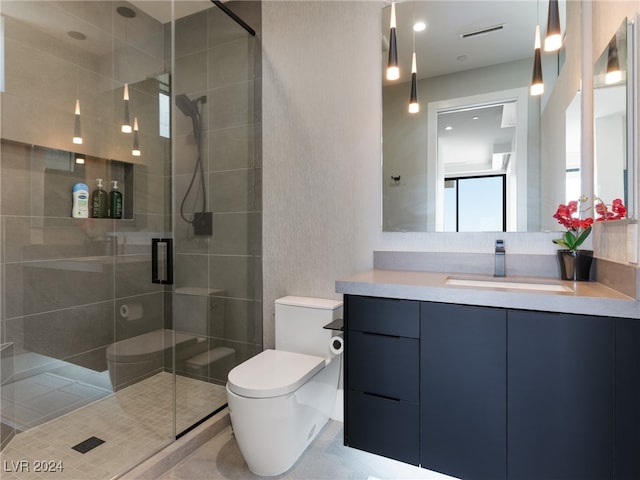 bathroom featuring a shower with door, toilet, and vanity