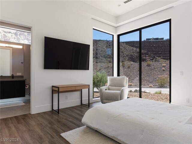 bedroom with dark wood-type flooring and ensuite bath