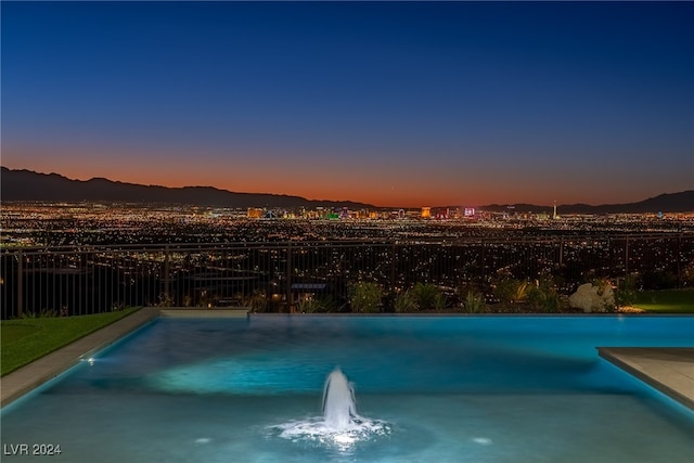 pool at dusk with pool water feature