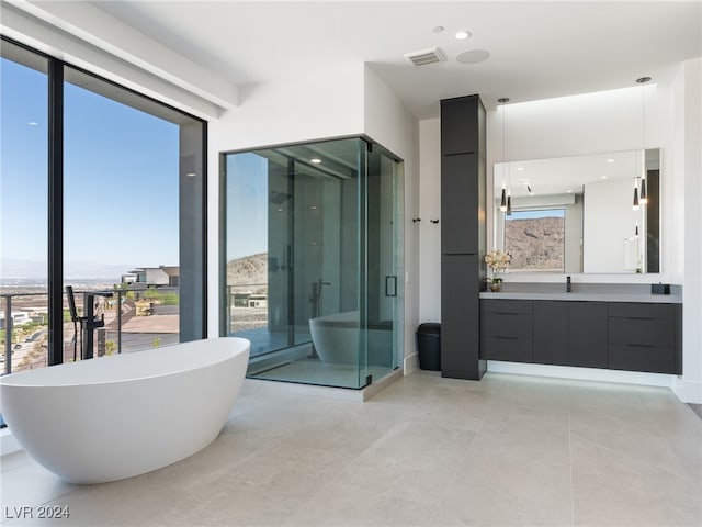 bathroom featuring tile patterned flooring, independent shower and bath, and vanity