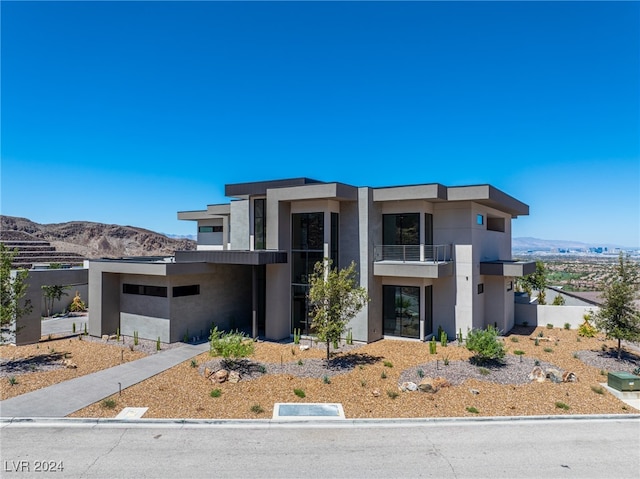 view of front of house featuring a balcony and a mountain view