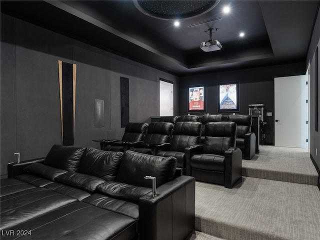 carpeted home theater featuring a raised ceiling