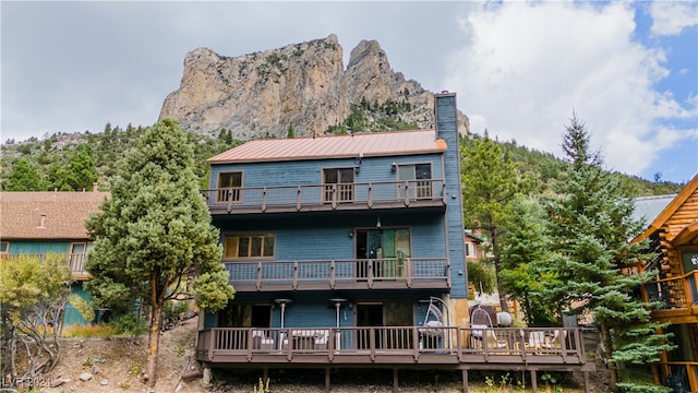 back of house featuring a balcony and a mountain view