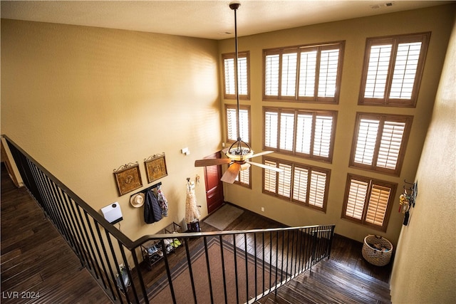 stairway with ceiling fan and wood-type flooring