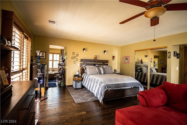 bedroom featuring ceiling fan, dark wood-type flooring, and a closet