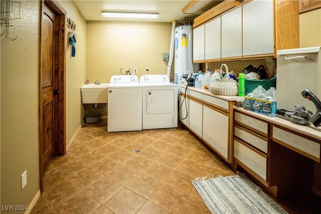 washroom with light tile patterned flooring, sink, water heater, cabinets, and washer and dryer