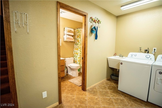 laundry area featuring sink, light tile patterned flooring, and washer and clothes dryer