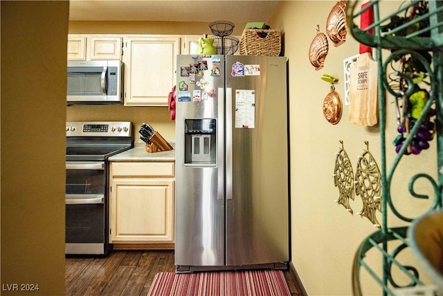 kitchen with appliances with stainless steel finishes and dark hardwood / wood-style floors