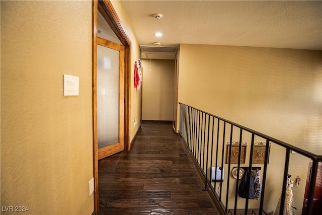 hallway featuring a textured ceiling and dark hardwood / wood-style floors