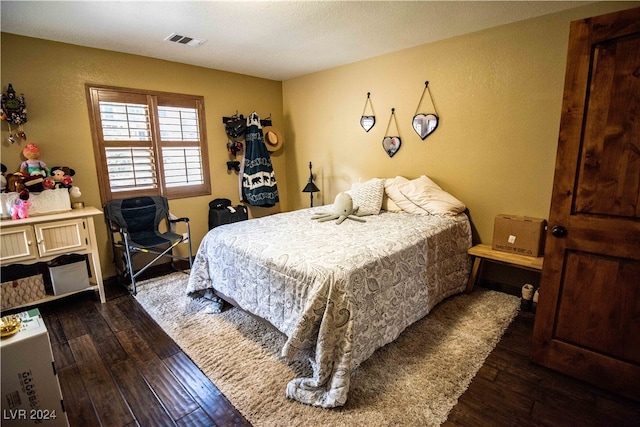 bedroom with dark hardwood / wood-style floors