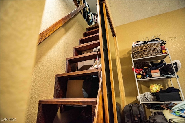 stairway featuring a textured ceiling