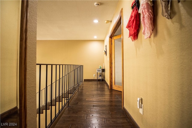 hall featuring a textured ceiling and dark hardwood / wood-style flooring