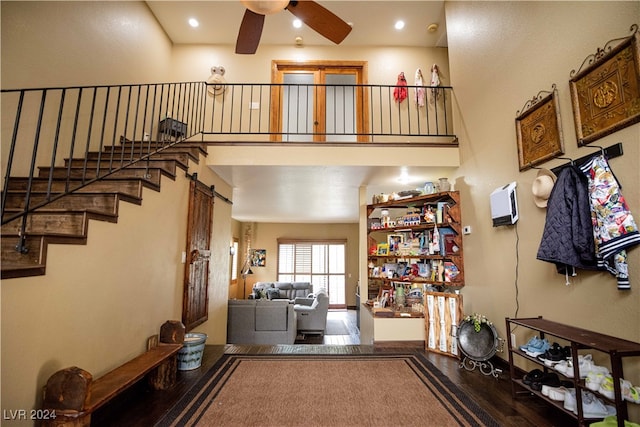 entrance foyer with ceiling fan, hardwood / wood-style floors, and a high ceiling